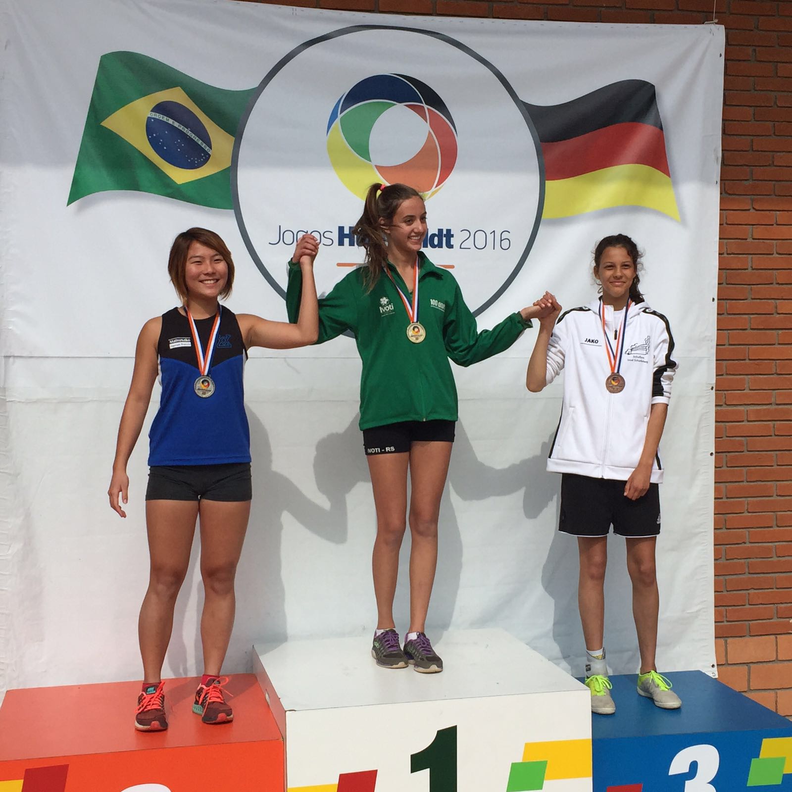 3 Mädchen stehen auf dem Siegerpodest.